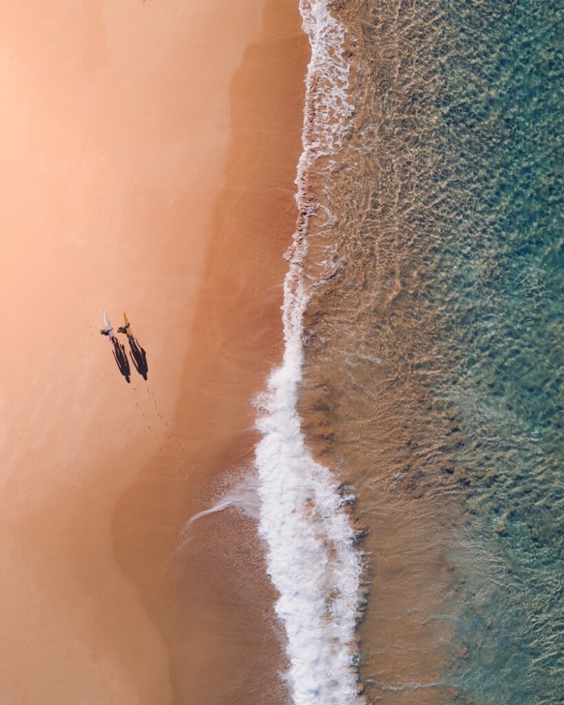 Two surfers walking on the beach